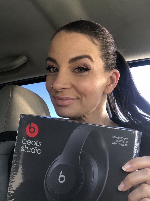 Cliente da The Box mostrando um fone Beats Studio ainda lacrado que veio na caixa