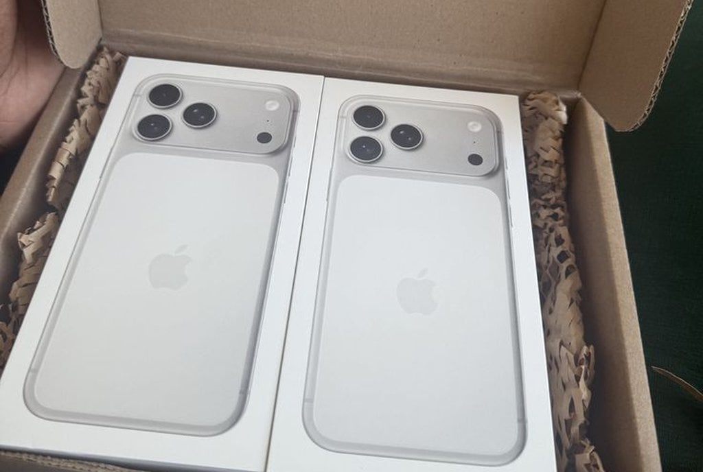 Caixa de papelão aberta com dois iPhone 17 lacrados na embalagem original